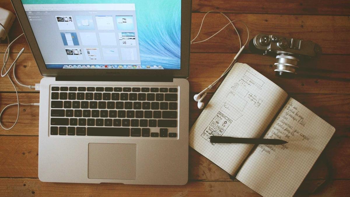 Laptop and notebook on a wooden desk